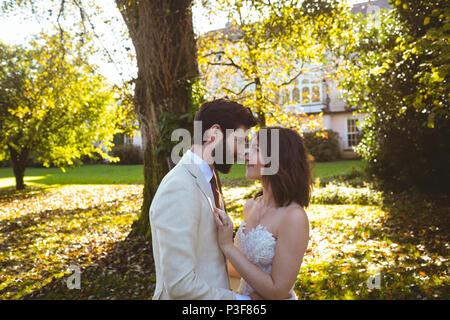 Bride and groom looking into each other eyes in the garden Stock Photo