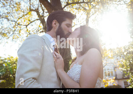 Bride and groom kissing in the garden Stock Photo