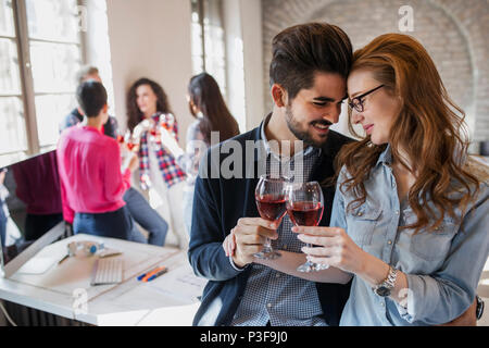 Happy young architects having break and drinking wine Stock Photo