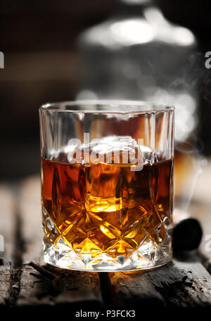 Cigar and glass with whiskey with ice cubes Stock Photo