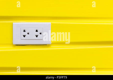 White electric plugs on modern yellow wallpaper, with copy space background. Stock Photo