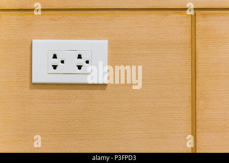 White electric plugs on vintage brown wood wall, with copy space background. Stock Photo