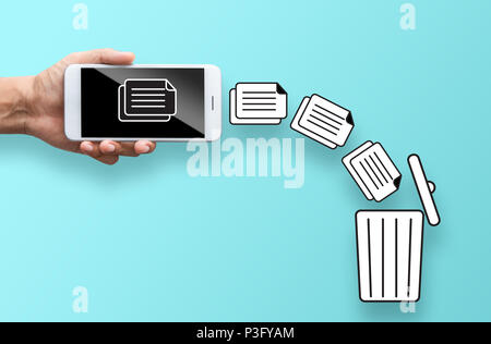 business hand throw data file from mobile to trash bin Stock Photo