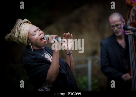 Ley Adewole lead vocalist of The Grace Notes performing at Trebah Garden amphitheatre in Cornwall. Stock Photo