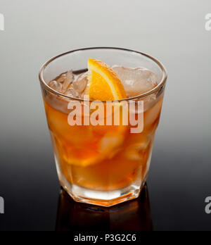 Closeup glass of negroni cocktail decorated with citrus on dark background. Stock Photo