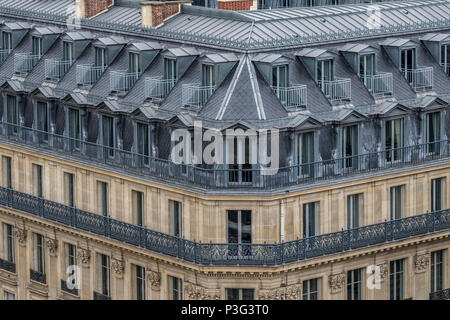 The  elegant  grey slate rooftops of Paris apartment buildings a running balcony and attic rooms, Boulevard Haussmann ,Paris ,France Stock Photo