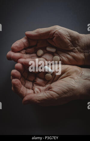 Senior womans cupped hands holding tablets Stock Photo