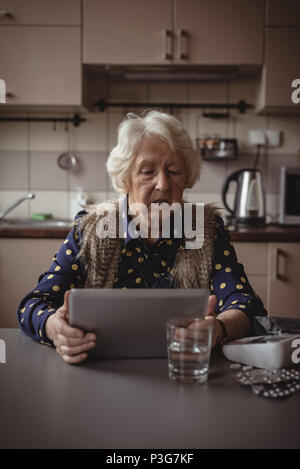 Senior woman using digital tablet in the kitchen Stock Photo