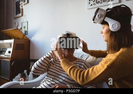 Senior woman and daughter wearing a virtual reality headset Stock Photo