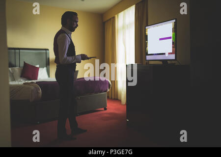 Businessman watching tv in room Stock Photo