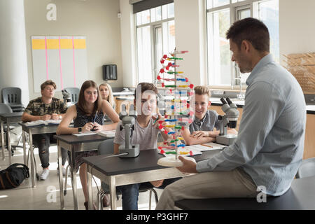 Teacher assisting students in experiment on molecule Stock Photo