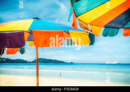 Two colorful sunshades in the beach on a sunny summer day. Summer background with colorful beach umbrellas Stock Photo