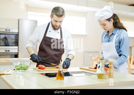 Two Professional Chefs Cooking in Restaurant Stock Photo