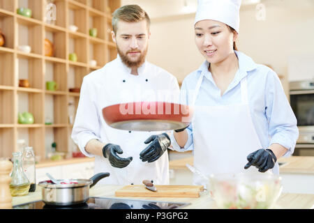 Cheerful Chefs Working in Kitchen Stock Photo