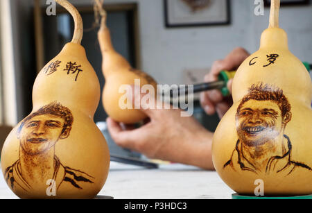 Zouchen, Zouchen, China. 18th June, 2018. Zoucheng, CHINA-18th June 2018: The folk artist Liu Yongjun makes gourd pyrography handicrafts in Zoucheng, east China's Shandong Province, marking the ongoing World Cup 2018. The portraits of famous football stars including Lionel Messi, Neymar da Silva Santos JÃƒÂºnior and Cristiano Ronaldo can be seen on the gourds. Credit: SIPA Asia/ZUMA Wire/Alamy Live News Stock Photo