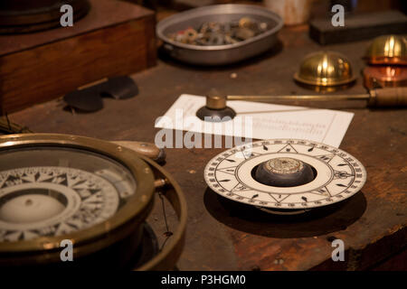 Different vintage nautic instruments sitting on a wooden table Stock Photo