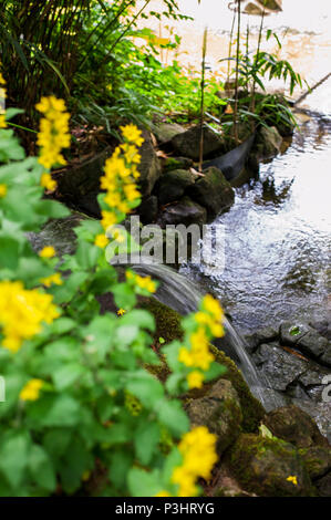Small, artificial waterfall in the public park, Luxembourg Stock Photo