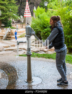 Young woman playing with water in a public park, Luxembourg