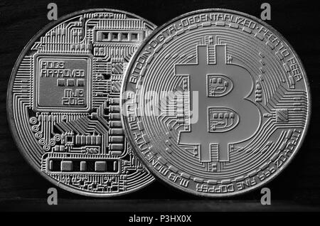 Two new silver physical bitcoins lies on dark wooden backgound, close up. High resolution photo. Cryptocurrency mining concept Stock Photo