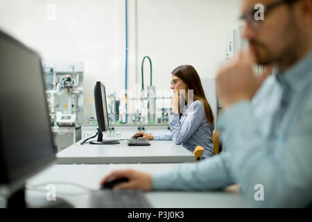 Side view of focused students using desktop pc in classroom at Technical faculty Stock Photo