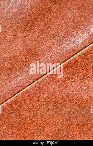 Brown leather texture. Useful as background for any design work. Macro photography of outerwear made of genuine leather Stock Photo