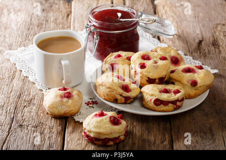 Freshly baked English scones with berry, tea with milk and jam close-up on the table. horizontal Stock Photo
