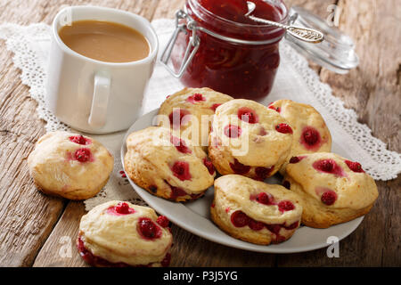 English buns sconces with red currants are served with English tea and jam close-up on the table. horizontal Stock Photo