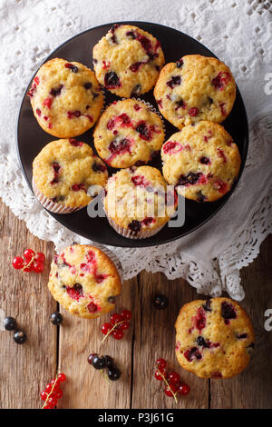 Summer dessert: muffins with a berry mix of currants close-up on the table. Vertical top view from above Stock Photo