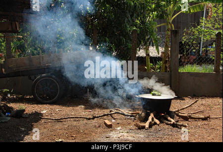 The day before a Cambodian wedding the family prepares the wedding feast, cooking outdoors in large pots over fires. Stock Photo