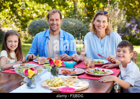 Parents and kids having a lunch together in the garden Stock Photo