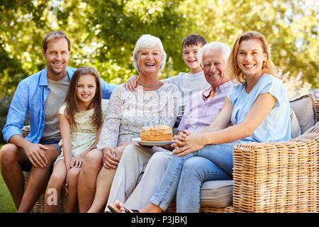 Three generation family sitting together in the garden Stock Photo