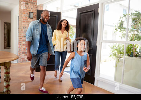 Mixed race couple and their daughter arriving home Stock Photo