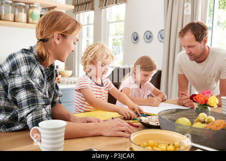 Young white family busy together in their kitchen, close up Stock Photo