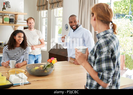 Four young adult friends having coffee in the kitchen Stock Photo