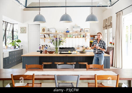 Young woman standing in an open plan kitchen dining room Stock Photo