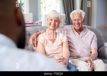Happy senior couple taking financial advice at home Stock Photo