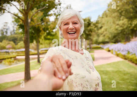 Point Of View Shot Of Senior Couple Walking In Park Together Stock Photo