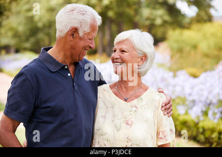 Senior Couple Enjoying Walk In Park Together Stock Photo