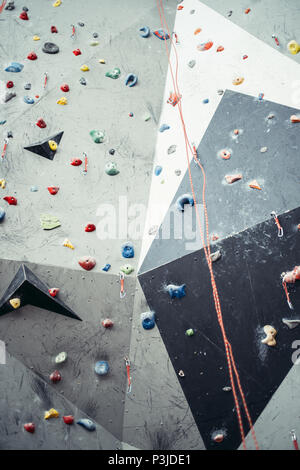 Artificial rock climbing wall with toe and hand hold studs. Stock Photo