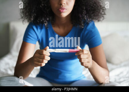 Sad Young Woman With Pregnancy Test At Home Stock Photo