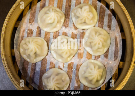 Traditional Chinese steamed dumplings in a bamboo steamer Stock Photo