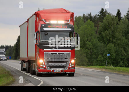 Red Volvo FH truck and full trailer of Konnekuljetus Oy trucking on highway, with auxiliary lights on for the photo. Uurainen, Finland - June 15, 2018 Stock Photo