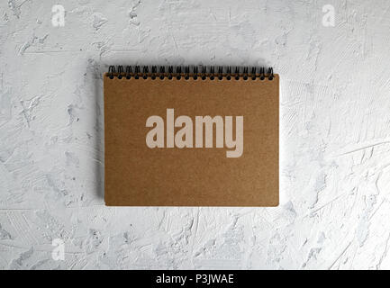 notebook on a black iron spring with brown empty sheets on a white background, close up Stock Photo