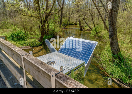 Solar Energy Panel powers a Smoky Mountain research station set up next to a stream going through the trees. Stock Photo
