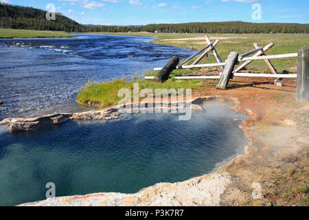 Maidens Grave Hot Spring flowing into the Firehole River in Yellowstone National Park in Wyoming United States Stock Photo