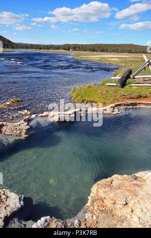 Maidens Grave Hot Spring flowing into the Firehole River in Yellowstone National Park in Wyoming United States Stock Photo