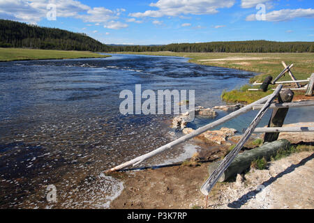 Maidens Grave Hot Spring flowing into the Firehole River in Yellowstone National Park in Wyoming United States Stock Photo