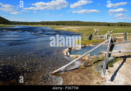 Maidens Grave Hot Spring flowing into the Firehole River in Yellowstone National Park in Wyoming United States Stock Photo