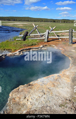 Maidens Grave Hot Spring flowing into the Firehole River in Yellowstone National Park in Wyoming United States Stock Photo