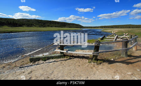 Maidens Grave Hot Spring flowing into the Firehole River in Yellowstone National Park in Wyoming United States Stock Photo